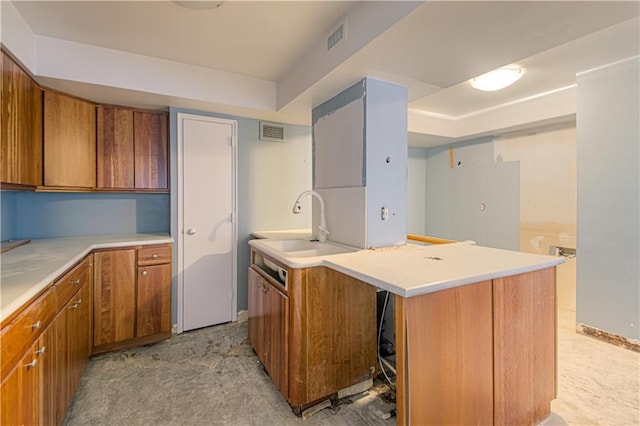 kitchen with a raised ceiling, a kitchen island, and sink