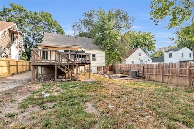 rear view of house featuring a deck, a lawn, and an outdoor fire pit