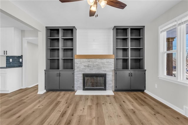 unfurnished living room with plenty of natural light, a fireplace, and light hardwood / wood-style floors