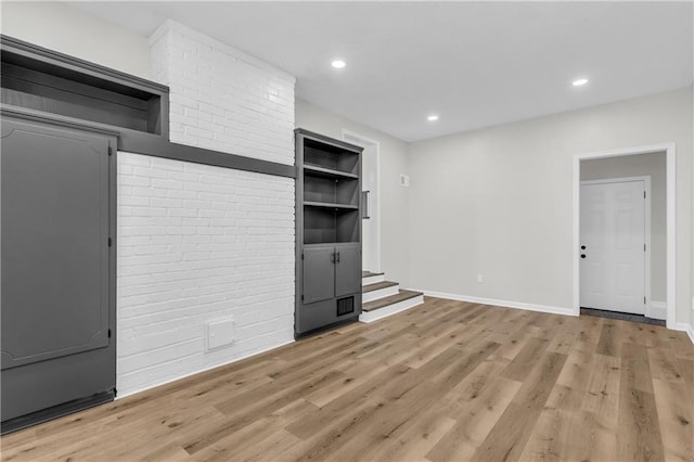 unfurnished living room with built in features and light wood-type flooring