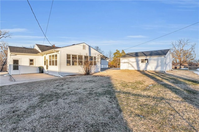 rear view of house featuring a yard, an outbuilding, and a patio area