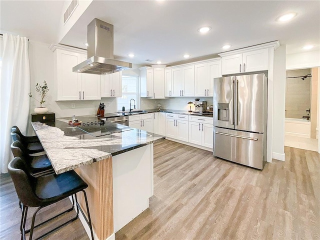 kitchen featuring white cabinetry, island range hood, and stainless steel fridge with ice dispenser