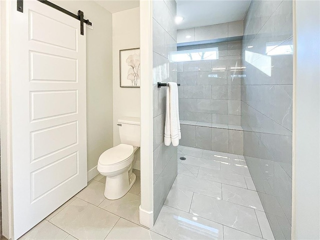 bathroom featuring a tile shower and toilet