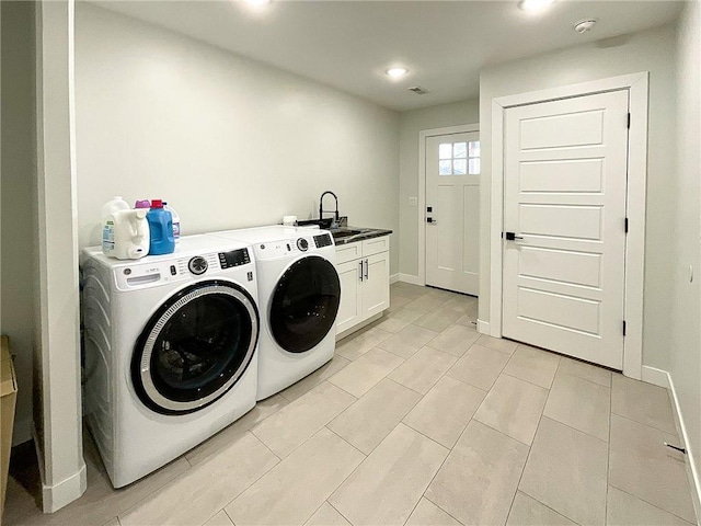 laundry area featuring cabinets, separate washer and dryer, and sink