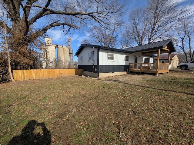 rear view of property featuring a yard and a deck