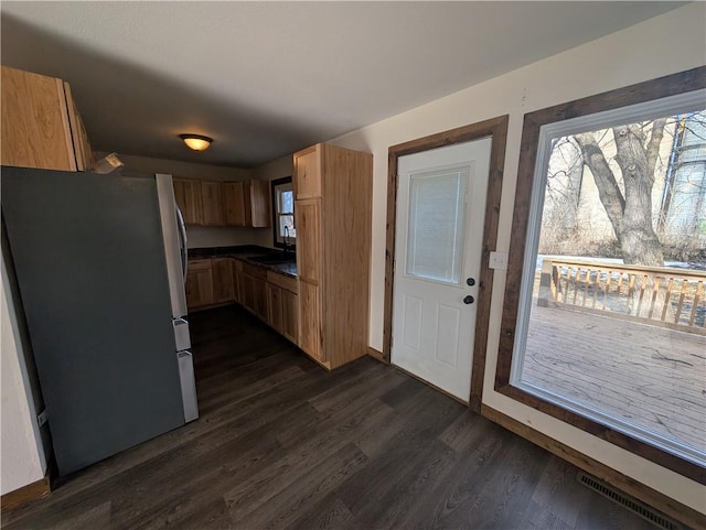 kitchen with dark hardwood / wood-style flooring and stainless steel refrigerator