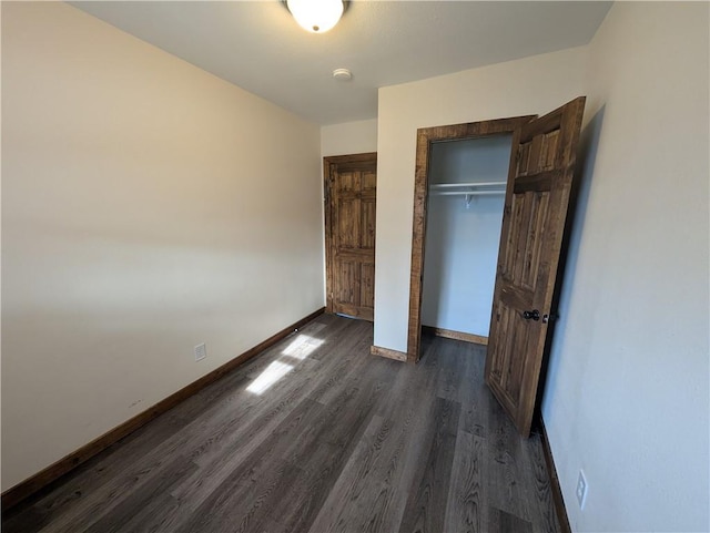 unfurnished bedroom featuring dark hardwood / wood-style floors and a closet