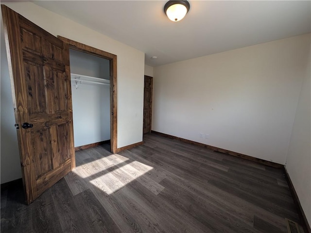 unfurnished bedroom with dark hardwood / wood-style floors and a closet