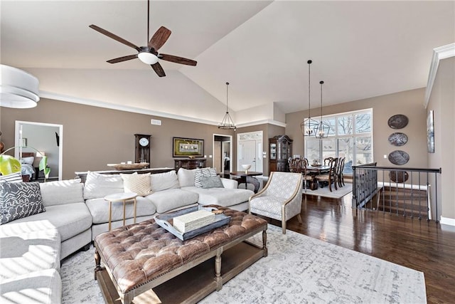 living room featuring high vaulted ceiling, ceiling fan with notable chandelier, and dark hardwood / wood-style flooring