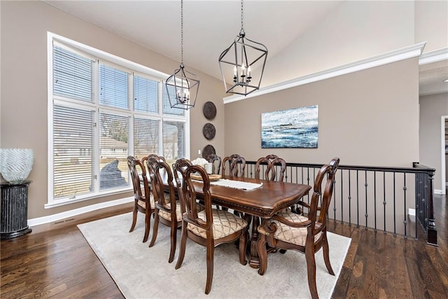 dining room with high vaulted ceiling and dark hardwood / wood-style floors