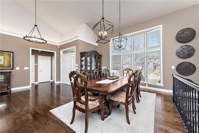 dining space with dark hardwood / wood-style floors, a notable chandelier, and high vaulted ceiling