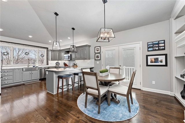 dining area featuring sink, dark wood-type flooring, french doors, and vaulted ceiling