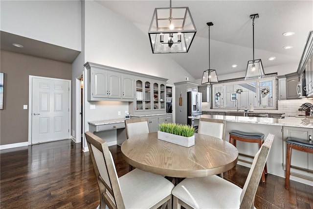 dining room featuring an inviting chandelier, dark hardwood / wood-style floors, and high vaulted ceiling