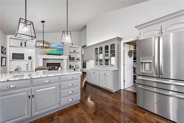 kitchen featuring gray cabinets, hanging light fixtures, lofted ceiling, and stainless steel fridge with ice dispenser