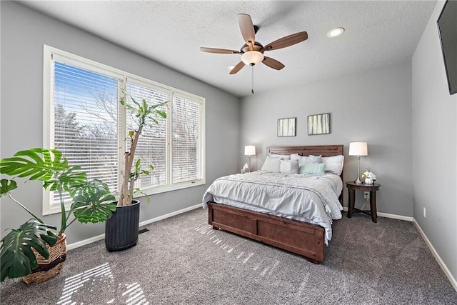 bedroom featuring ceiling fan, a textured ceiling, and dark colored carpet