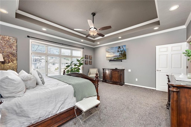 bedroom with crown molding, ceiling fan, a tray ceiling, and carpet