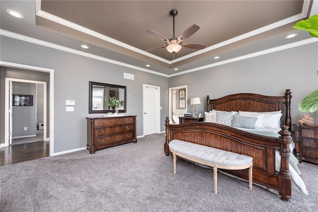 carpeted bedroom featuring a tray ceiling, ornamental molding, and ceiling fan