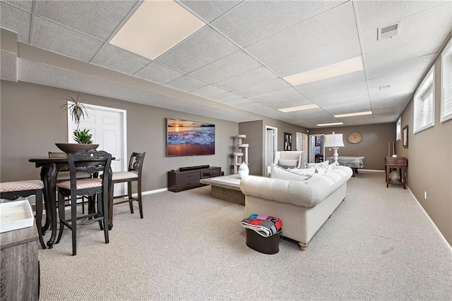 carpeted living room featuring a drop ceiling