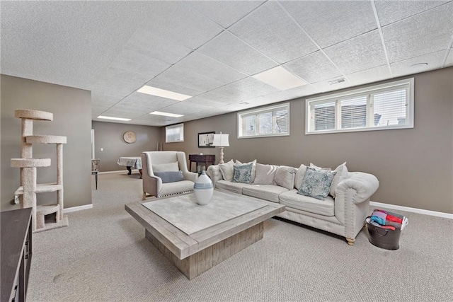 carpeted living room with plenty of natural light and a drop ceiling