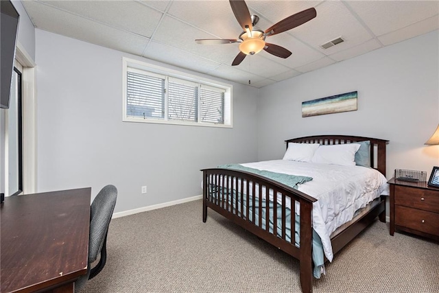 carpeted bedroom featuring a drop ceiling and ceiling fan