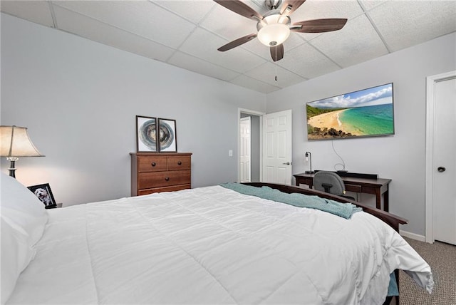 bedroom with carpet floors, a drop ceiling, and ceiling fan