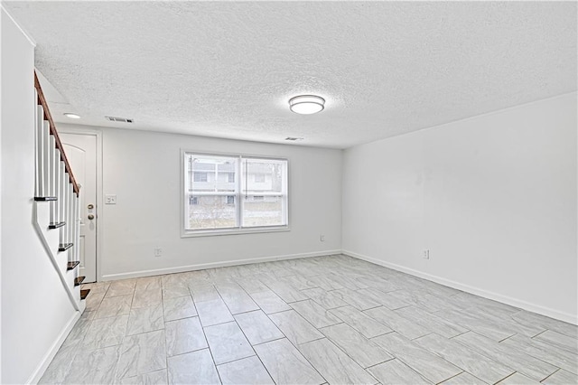 empty room featuring a textured ceiling