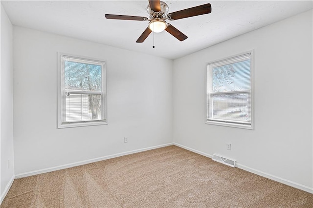 carpeted spare room featuring ceiling fan