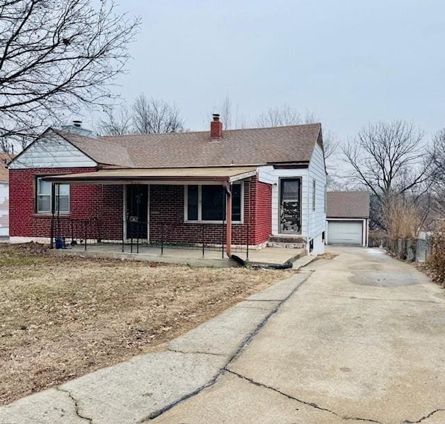 view of front of property featuring a garage, an outdoor structure, and covered porch