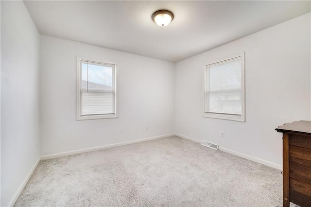 spare room featuring light colored carpet