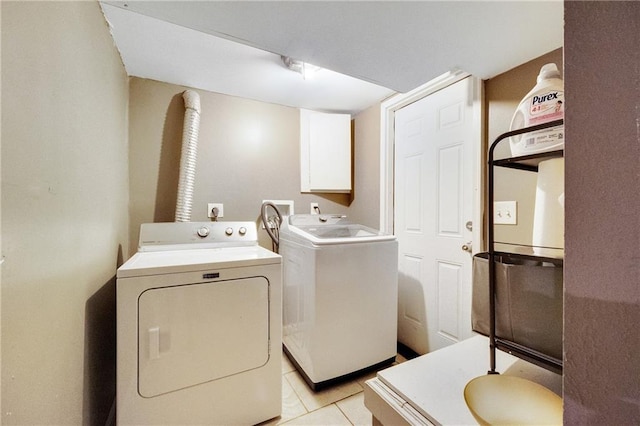 clothes washing area featuring washer and clothes dryer and light tile patterned floors