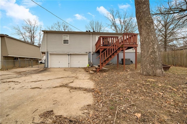 back of house featuring a wooden deck, a garage, and central air condition unit