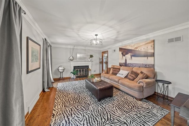 living room with a notable chandelier, crown molding, and wood-type flooring