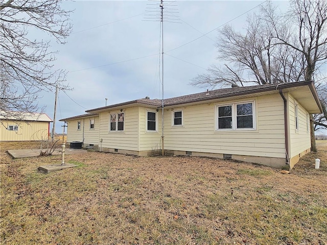 back of house featuring crawl space, cooling unit, and a lawn