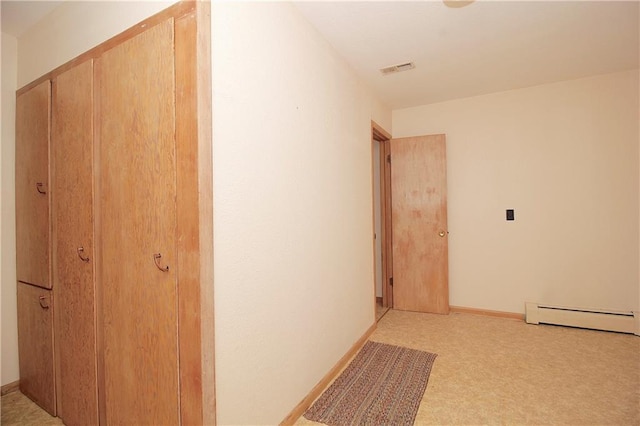 hall with a baseboard radiator, visible vents, light carpet, and baseboards