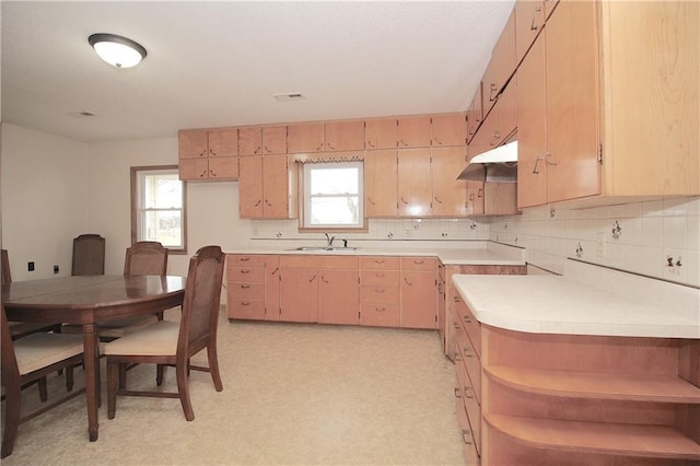 kitchen featuring light countertops, light brown cabinetry, light floors, open shelves, and a sink