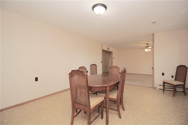 dining space with light carpet, a baseboard radiator, and baseboards