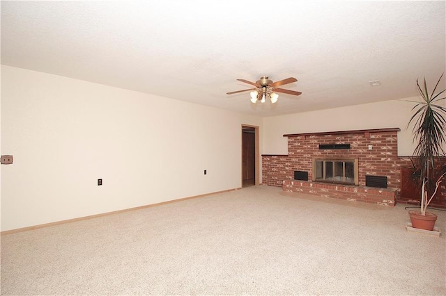 unfurnished living room featuring a ceiling fan, a brick fireplace, carpet flooring, a textured ceiling, and baseboards