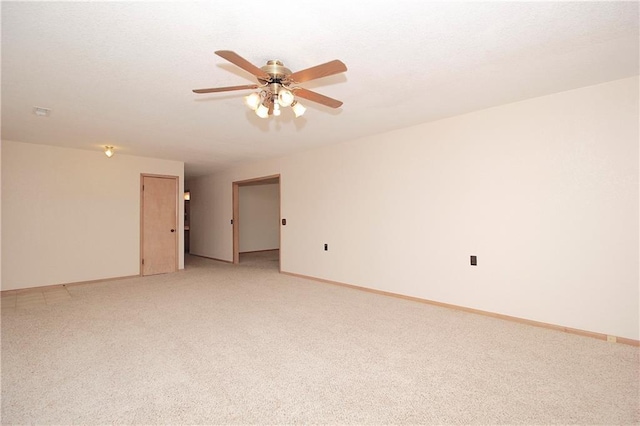 empty room with ceiling fan, baseboards, and light colored carpet