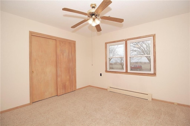 unfurnished bedroom with carpet, a closet, and baseboard heating
