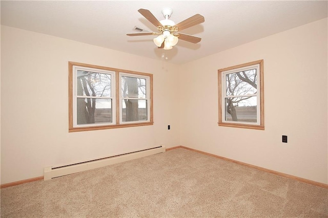 spare room with a baseboard heating unit, ceiling fan, carpet floors, and baseboards