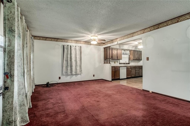 unfurnished living room with a textured ceiling, baseboards, a ceiling fan, and light colored carpet