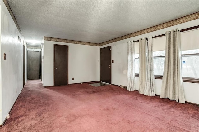 carpeted spare room with a textured ceiling