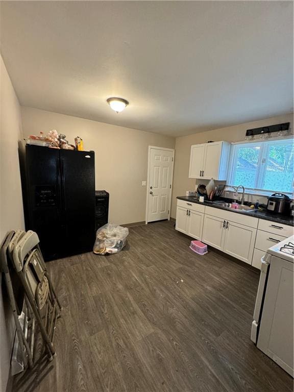 kitchen featuring sink, dark hardwood / wood-style flooring, white cabinets, black fridge, and white range