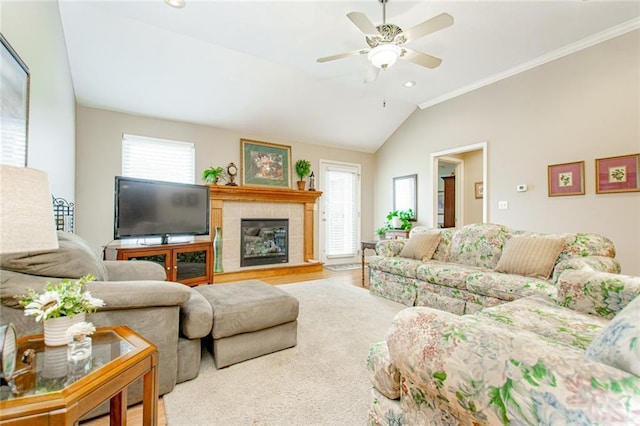 living room featuring lofted ceiling, crown molding, a tile fireplace, and ceiling fan