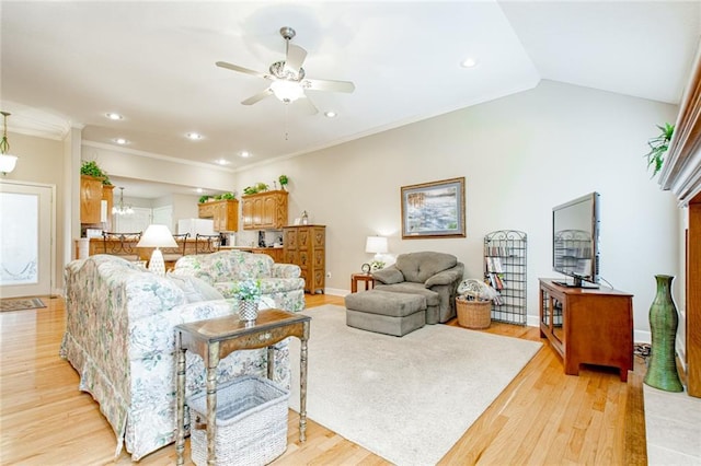 living room featuring lofted ceiling, crown molding, ceiling fan with notable chandelier, and light wood-type flooring