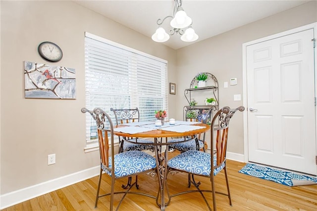 dining area with hardwood / wood-style flooring and an inviting chandelier