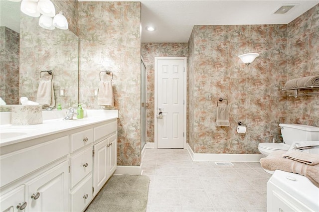 bathroom featuring walk in shower, vanity, toilet, and tile patterned flooring