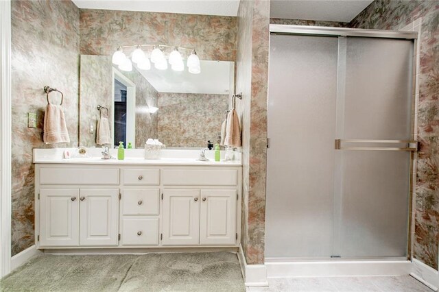 bathroom with vanity and a shower with door