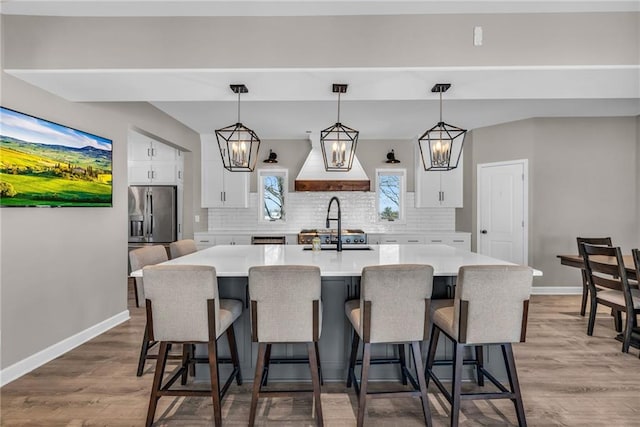 kitchen featuring light countertops, a kitchen island, decorative light fixtures, and a kitchen breakfast bar