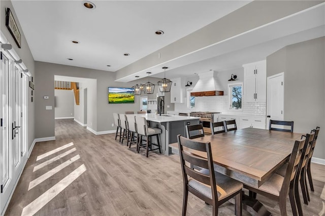 dining space with light wood-style flooring and baseboards